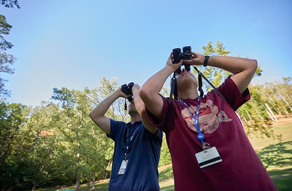 Students outside with binoculars 