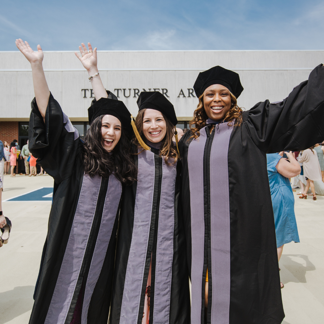 3 people in cap and gown