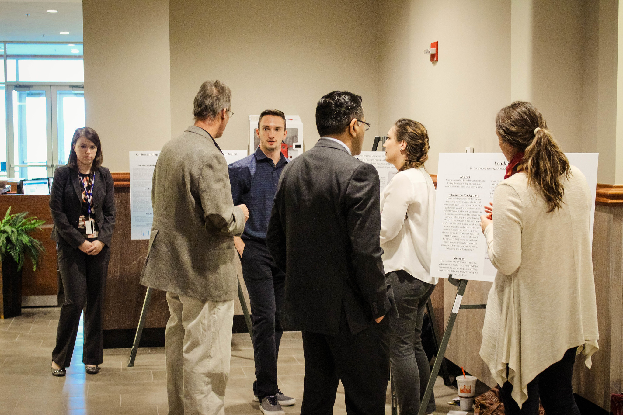 A group of people together looking at a poster presentation