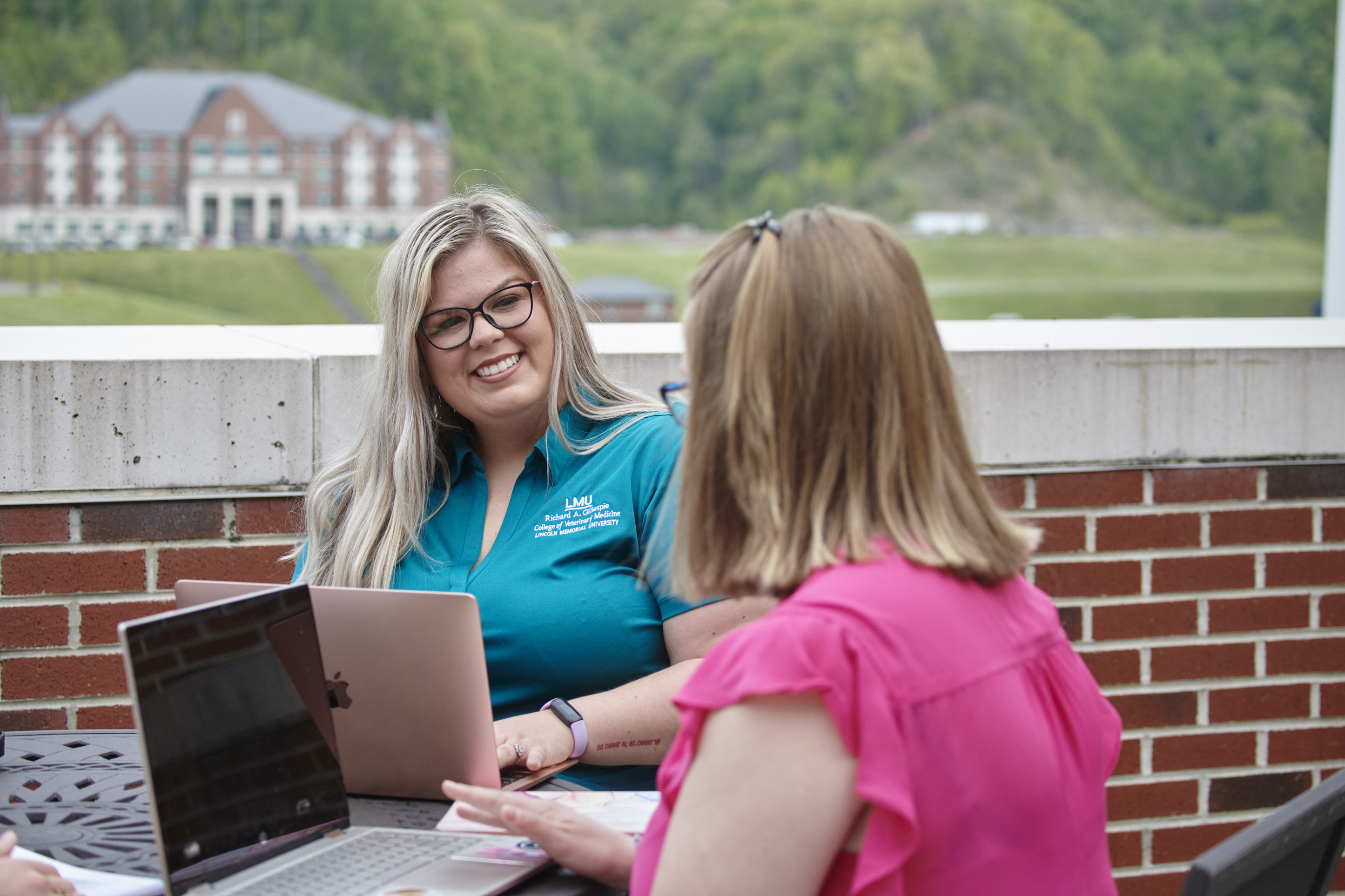 Two girls smiling while studying