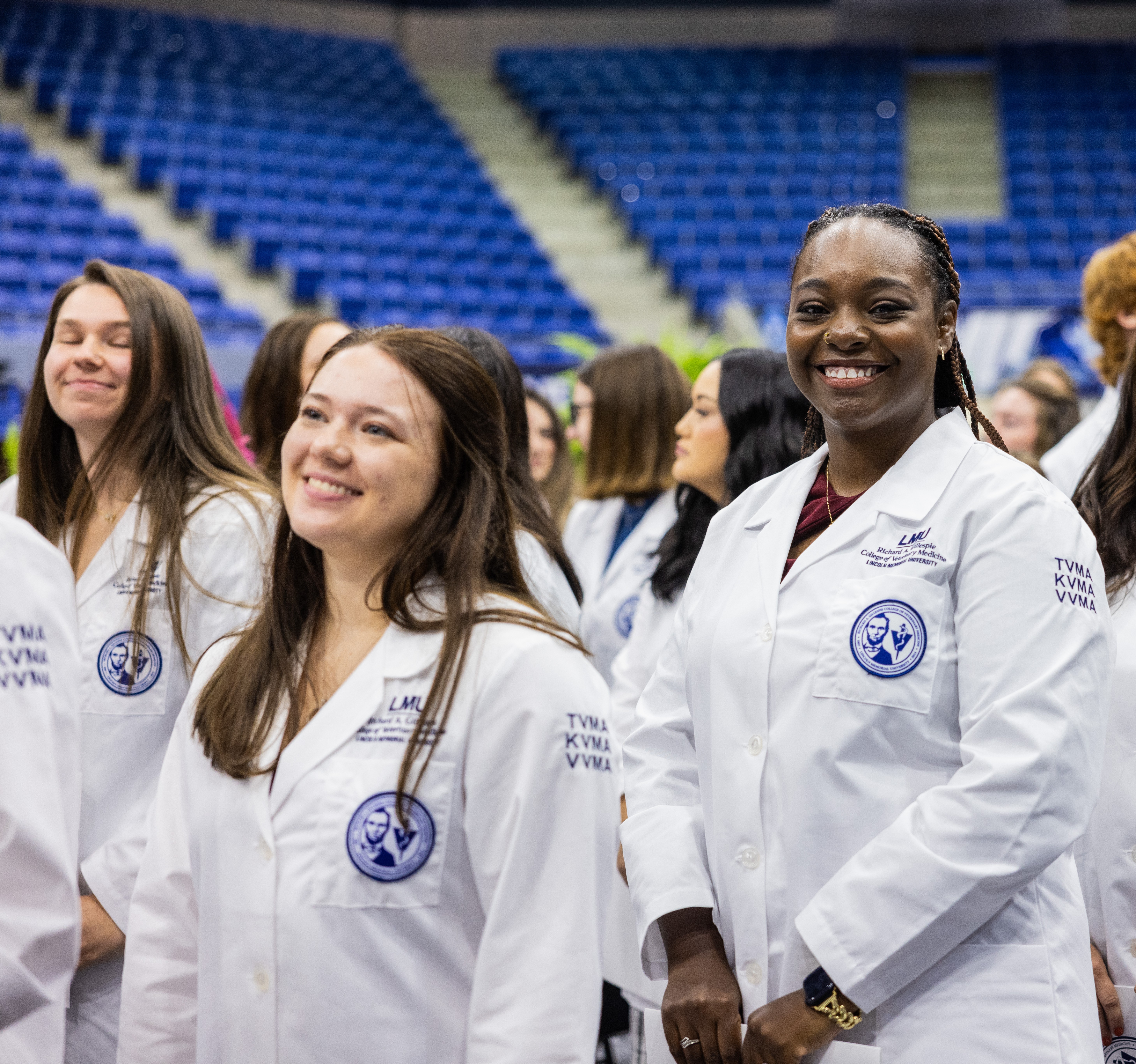 Students in their DVM white coat smiling