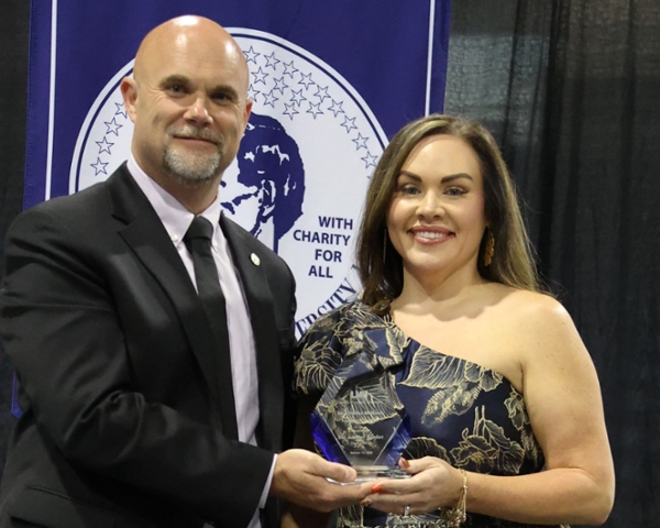 Kinder receiving award from president Jason McConnelll